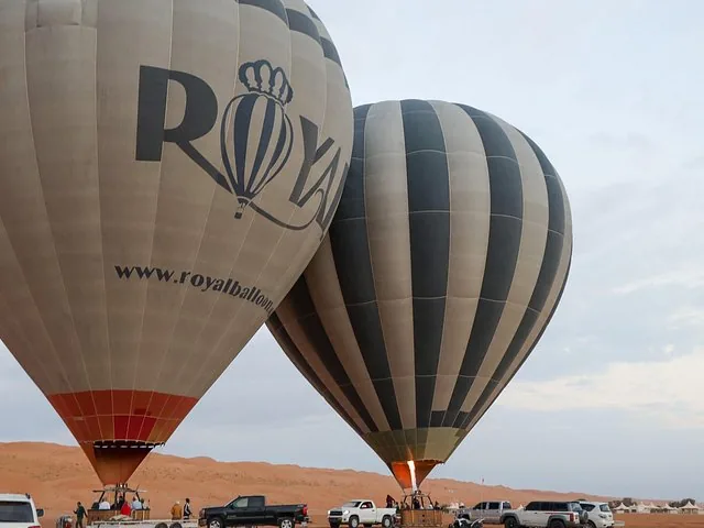 Globos aerostáticos preparándose para despegar en el desierto al amanecer.